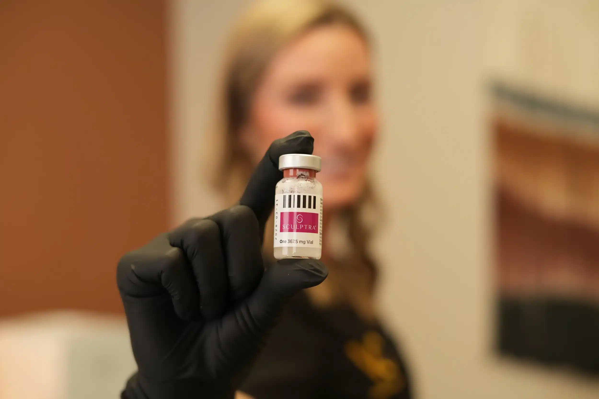 Maureen McSwiggin holding a vial of Sculptra.