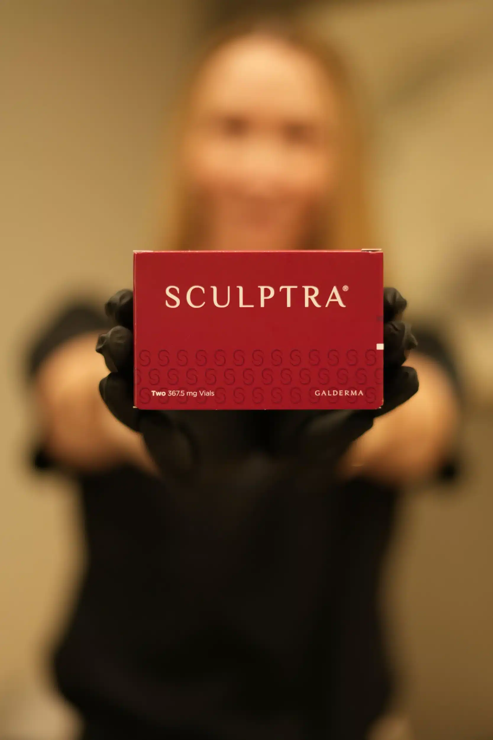 Sculptra box held by a person at Vitality Collective Aesthetics & Wellness.